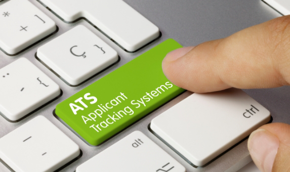 A close-up image of a person pressing a green key on a keyboard labeled "ATS Applicant Tracking Systems." The surrounding keys on the keyboard are white, and the person's finger is positioned over the green key.
